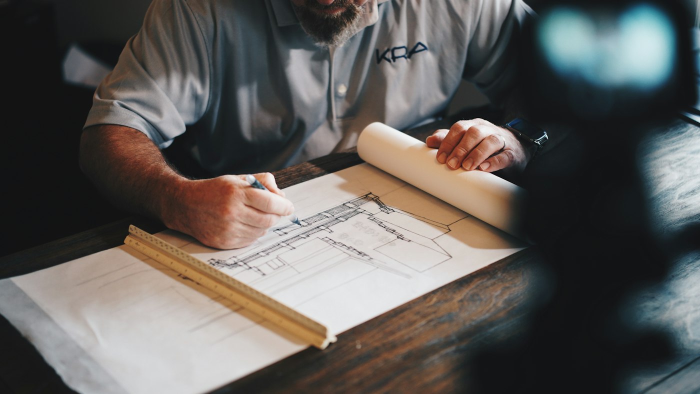 Carpenter measuring and marking up plans for a joinery project